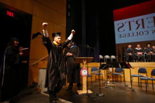 graduate raising hands in triumph